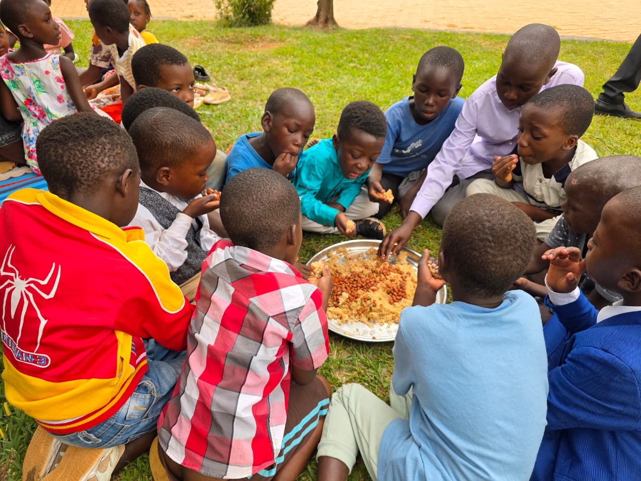 Children sharing a meal together on the grass